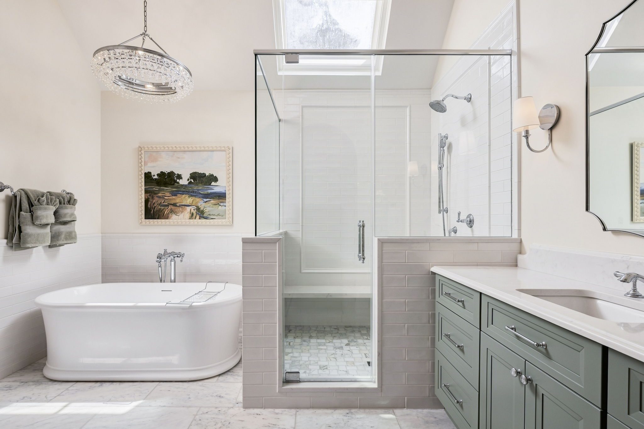 Remodeled bathroom with a glass-enclosed shower, freestanding tub, sage green vanity and marble floor