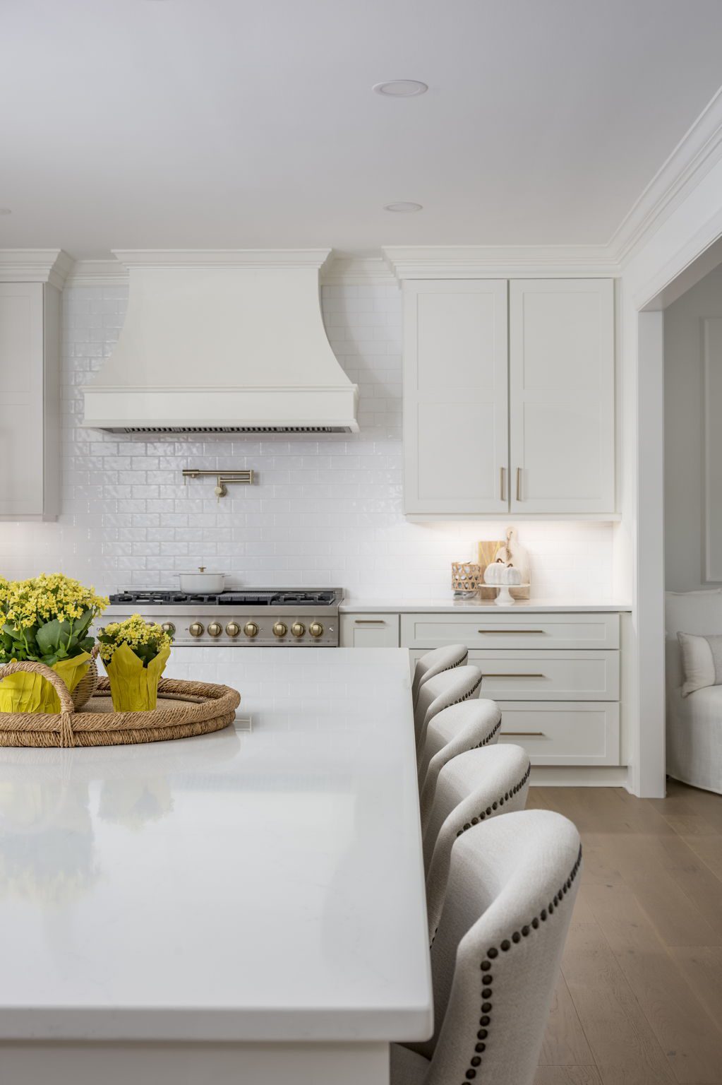 Custom curved white range hood above a 48-inch dual-fuel range with a handmade tile backsplash