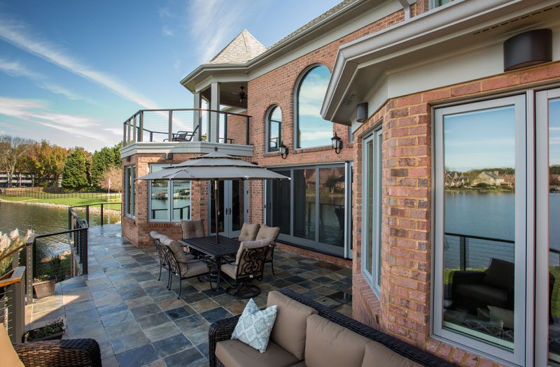 Brick house with a large covered patio and outdoor living furniture